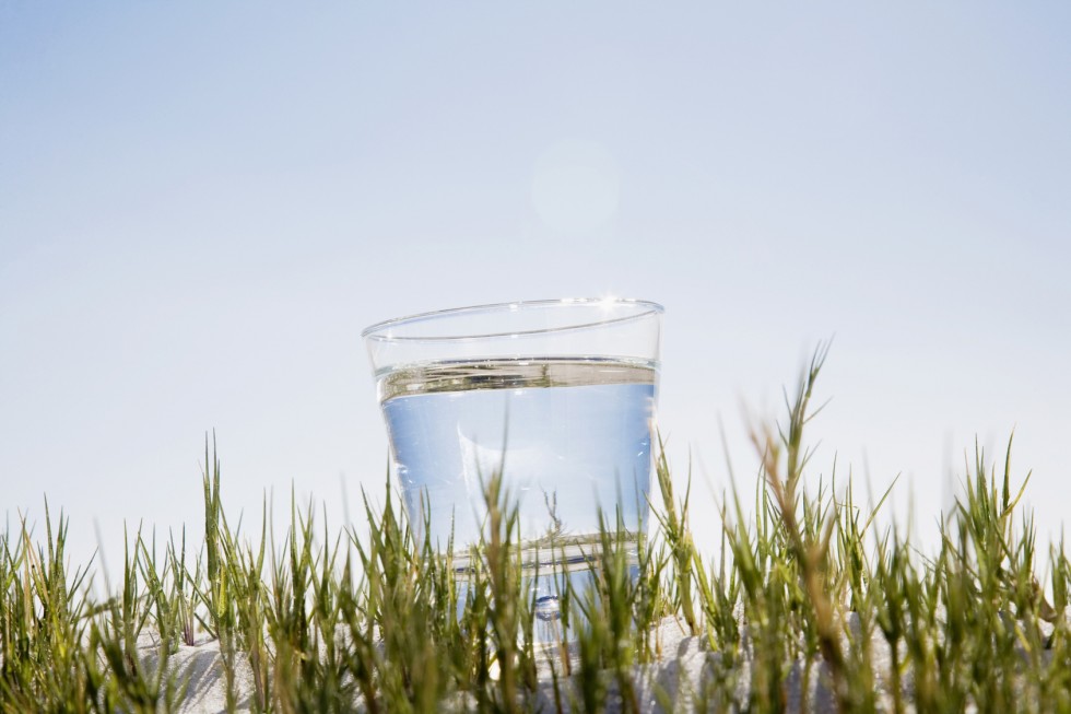 Wasserglas steht auf einer Düne